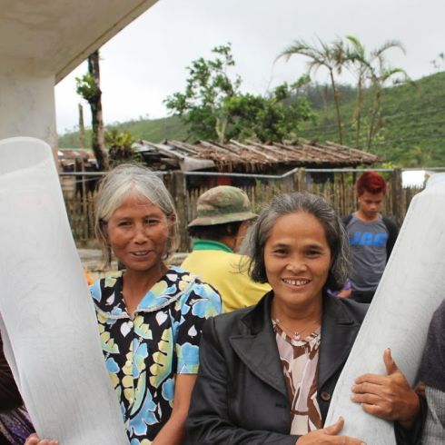 Frauen aus der Nähe von Ormoc, in der Region Leyte, erhalten Baumaterial von CARE zum Wiederaufbau ihrer Häuser. (Foto: CARE)