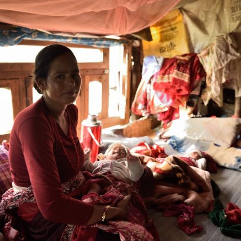 Die 32-Jährige Maili Bharati mit ihrem Neugeborenen Laxman. Im Hintergrund schläft sein Zwillingsbruder Ram. Die Beiden erblickten während des Erdbebens 2015 in Nepal das Licht der Welt. (Foto: CARE/Lucy Beck)