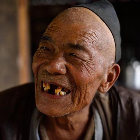 Singi Bomjan erlebte bereits das Erdbeben 1934 in Nepal. Bei dem diesjährigen Erdbeben verlor er seine Tochter und sieben Enkelkinder. CARE unterstützt ihn nun mit Bargeldauszahlungen, die der lebensfrohe Singi bereits verplant hat. (Foto: CARE/Lucy Bec