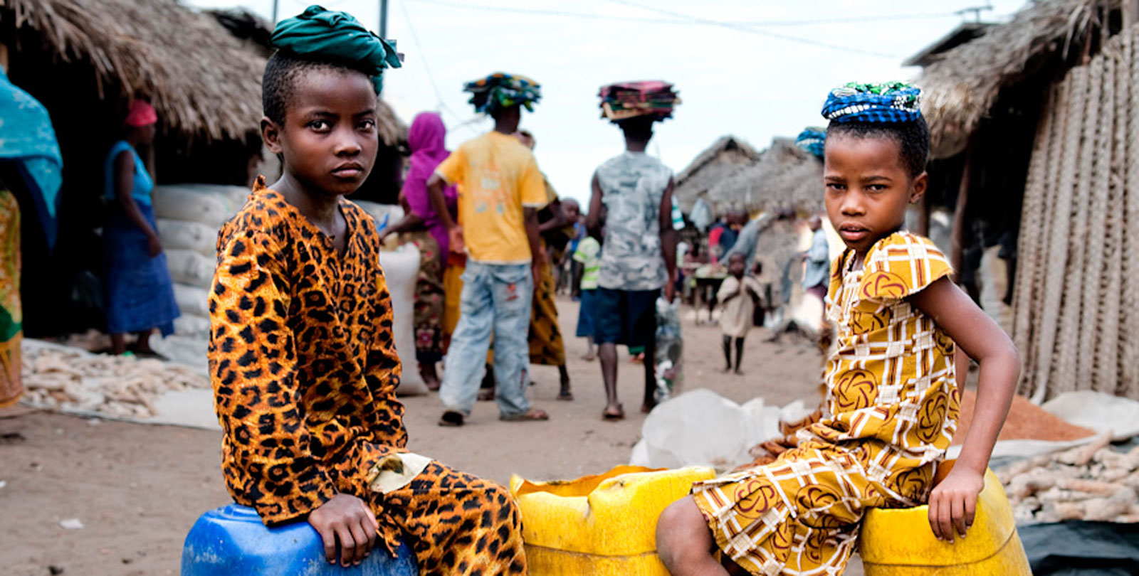 Mozambique: deux enfants sont assis sur des jerricans d'eau