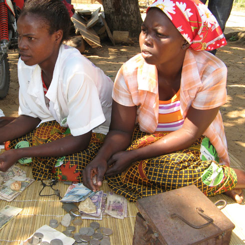 Deux femmes sont assis au sol et comptent de l'argent.