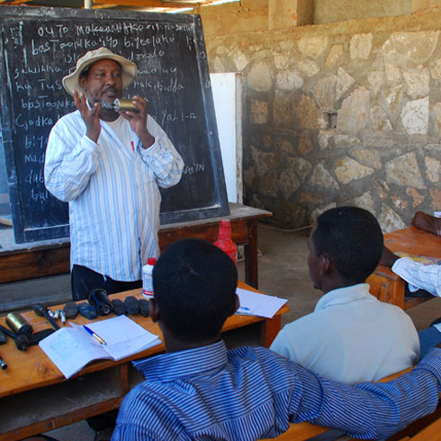 Un professeur donne des cours à des hommes dans une école.