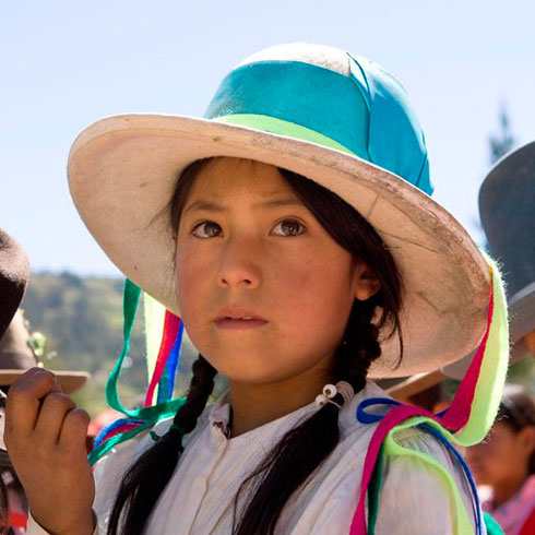 Une fille timide porte un chapeau.  