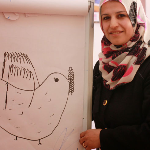Une femme se tient à côté d'un panneau sur lequel est dessiné une colombe de paix.