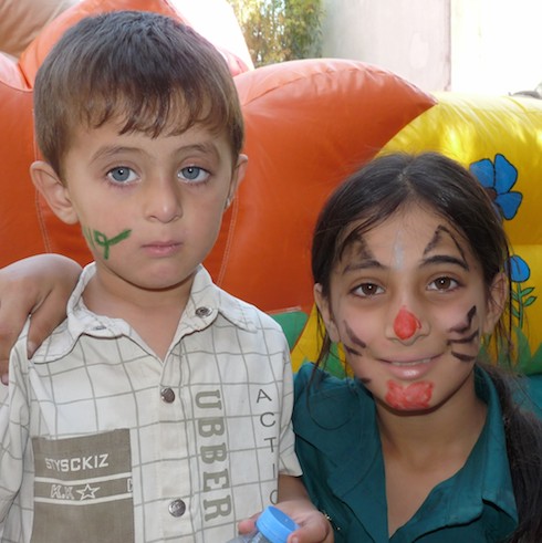 Deux enfants maquillés regardent l'appareil photo.