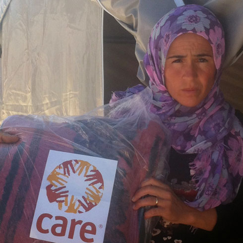 Une femme tient une couverture de CARE dans ses mains