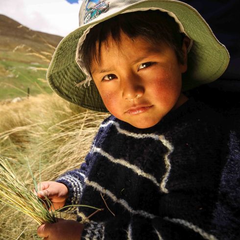 Un enfant portant un chapeau regarde l'appareil photo.