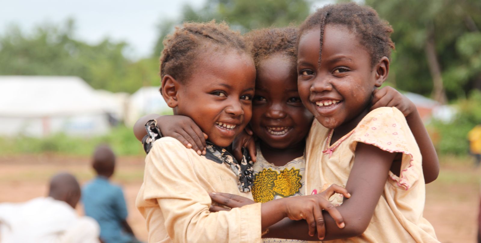Trois enfants tchadiens s'entrelacent.